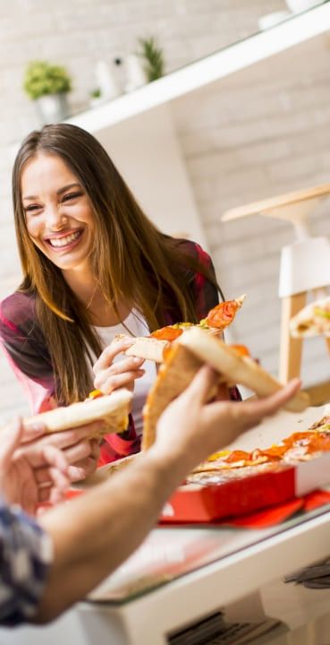 Eine Frau mit einem Stück Pizza in der hand